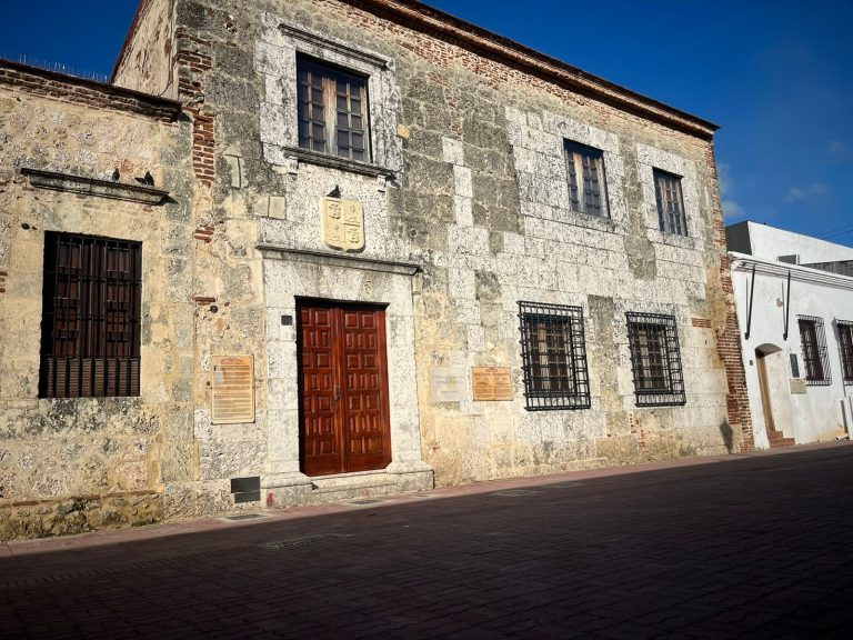 Presidentes de la Sociedad Dominicana de Bibliófilos y de la Fundación BHD en una mesa con el mantel de la Sociedad