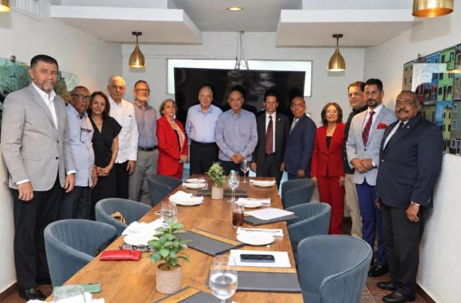 Directivos y miembros de la Sociedad Dominicana de Bibliófilos reunidos en torno a una mesa tras la asamblea general